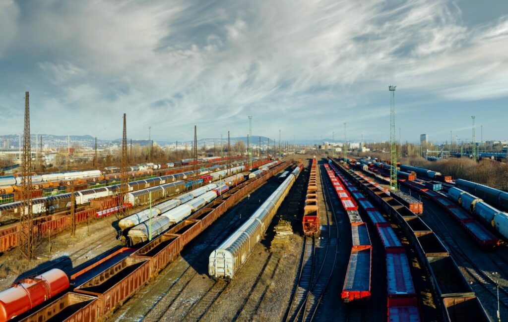 Picture of a lot of a parked freight trains in a railway station.