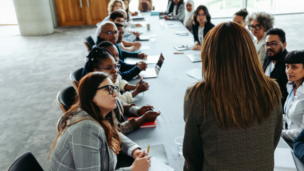 Manager leading business meeting with diverse team at large conference table
