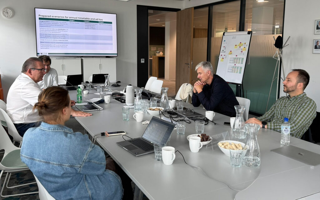 group of 5 workshop participants seated around a table discussing